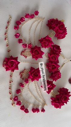 red roses and pearls are arranged on a table