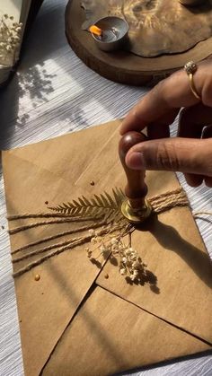 a person is making something out of brown paper with some scissors and other things on the table