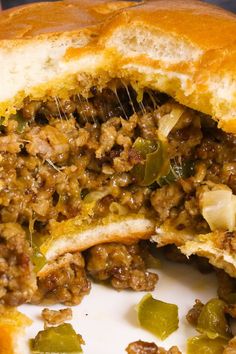 a close up of a sandwich on a plate with meat and vegetables cut in half