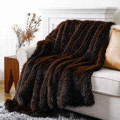 a white couch with a brown blanket on top of it