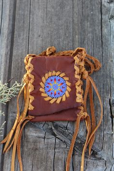 A beaded amulet bag made in rust colored leather with saddle lace. This small beaded pouch measures approximately 4 inches tall x 3 inches wide and has a braided neck strap that measures 28 inches. This is a very beautiful necklace bag where you can keep something very special close to your heart. Props are not included. This item is MADE TO ORDER. You will not receive the piece you see in the photos, we will make one similar for you. Please allow 3 to 4 weeks to ship and take the time to read o Beaded Brown Shoulder Bag Gift, Handmade Spiritual Bag For Festivals, Bohemian Beaded Shoulder Bag For Gift, Bohemian Hand-stitched Shoulder Bag As Gift, Small Beaded Necklace, Leather Medicine Pouch, Amulet Bag, Leather Medicine Bag, Beaded Pouch