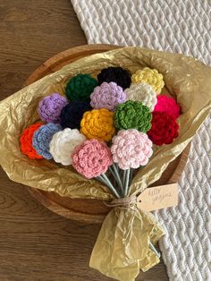 a bunch of crocheted flowers in a wooden bowl