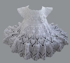 a white crocheted dress on a mannequin headdress with flowers