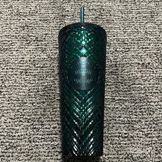 a green vase sitting on top of a carpet