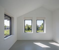 an empty room with three large windows in it