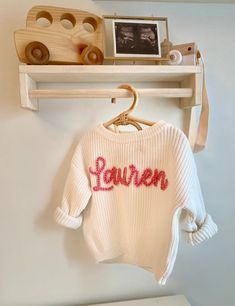 Knit infant sweaters with customized names for your little one! Perfect for a baby shower gift, gender reveal, name reveal, birthday present etc I will create 4 digital proofs of what the sweater will look like (4 different font choices) and will only begin production once you approve the design.  If there are any sweater or yarn colors (or larger sweater size) you would like but don't see available, just send me a message and we can make that happen :) (the turn around time might be a couple we Gender Reveal Just For Couple, Personalized Pink Crew Neck Sweater, Personalized White Sweater For Winter, Customizable Cute Crew Neck Sweater, Personalized Pink Long Sleeve Sweater, Cute Customizable Crew Neck Sweater, Personalized Pink Sweater For Winter, Personalized Cute Crew Neck Sweater, Cute White Sweater With Custom Embroidery