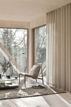 a living room filled with furniture and large windows overlooking the trees outside in front of them