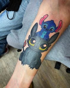 a person with a tattoo on their arm that has stitch and stitch characters on it