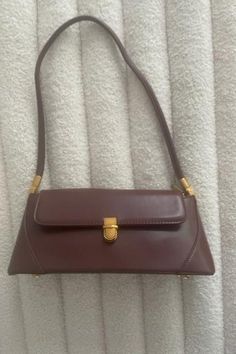 Get ready for fall with the must-have Audrey Bag! Its retro and classic design exudes chic style and will elevate any outfit. PU leather Imported Color: Burgundy Gold buckle and accents Approximate measurements: 11x4.7 in (Handle:10.62") Vintage Everyday Baguette Bag, Vintage Shoulder Baguette Bag, Vintage Baguette Shoulder Bag, Vintage Shoulder Bag With Metal Hardware, Vintage Shoulder Bag With Metal Hardware For Daily Use, Retro Baguette Satchel Bag For Everyday Use, Retro Satchel Baguette Bag For Everyday, Vintage Baguette Bag For Everyday Use, Classic Handheld Baguette Bag For Everyday