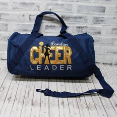 "This personalized travel bag with CHEER in gold applique is ready to hold all your stuff whether for after school practice, competitions or even a weekend at grandma's! Add a name for a super personalized on the go bag.    SEE PHOTOS FOR SIZE CHARTS AND POLICIES ABOUT OUR BAGS: 🐉 Choose a 12x18\" zipper top tote, OR small duffel - 18\", large duffel - 24\". Style and size chart shown in photos. PLEASE CHOOSE CAREFULLY. 🐉 Embroidered on a denier polyester bag- Made with 50% recycled material. Small Duffle Bag, Small Luggage, Cheer Bag, Cheer Girl, Go Bags, Gear Bag, Zipper Tote Bag, Zippered Tote, Overnight Bag