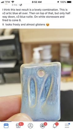 someone is holding up a glass block with blue and white swirls on the bottom