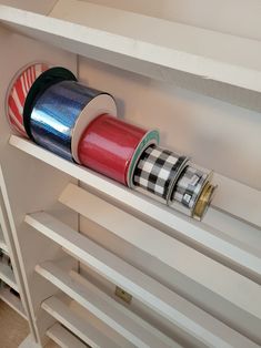 three rolls of tinsel wrapped in red, white and blue tape on a shelf