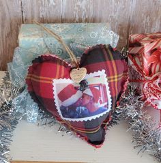 a heart shaped ornament sitting on top of a table next to wrapped presents