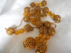 "Here we have a vintage pierced gold metal ball bead and faceted glass bead tassel necklace. This is 18\" with a 2 1/2\" tassel(longest one). Beads are about 10mm and bottom 2 about 12mm. These are a vintage item, please look at pictures. PLEASE convo me with any questions. Please check out my other items. Thanks for looking Elvira"