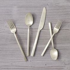 four forks, two spoons and one knife on a wooden table