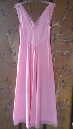 "70s gorgeous bubblegum pink nylon maxi slip / nightie by Vanity fair. The bust has delicate embroidered flower detail. Waist is accentuated with a deep V and a maxi length skirt part. Sheer hem and shoulder straps. **just very light 'scratch' marks on bottom of skirt but barely visible** Size 36 Nylon Length 55\", waist 28\" Made by vanity fair" Feminine V-neck Nightgown For Spring, Pink V-neck Sundress Maxi Dress, Summer V-neck Stretch Nightgown, Feminine V-neck Spring Nightgown, Spring V-neck Stretch Nightgown, Summer Stretch V-neck Nightgown, Pink Stretch Maxi Dress For Spring, Pink Stretch Maxi Dress For Summer, Pink V-neck Stretch Maxi Dress