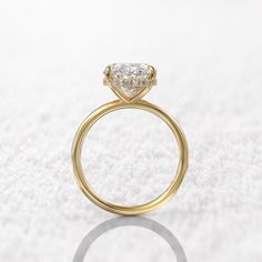 a yellow gold engagement ring with a pear shaped diamond