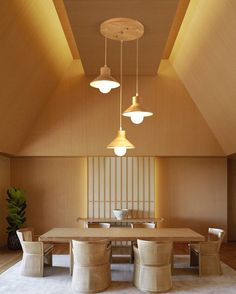 a dining table and chairs in a room with wood paneling on the walls, along with lights hanging from the ceiling