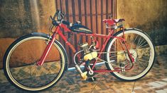 a red bike parked next to a building