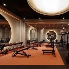 a gym with rows of exercise equipment and mirrors on the wall, all lit up