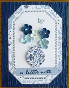 a blue and white card with flowers in a vase on the front, says a little note