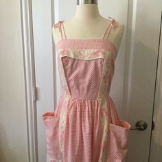 a mannequin wearing a pink and white dress with an apron on it's chest