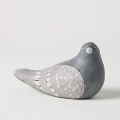 a gray and white bird figurine sitting on top of a table