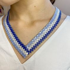 a woman wearing a blue and white necklace with two rows of beads on it's neck