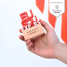 a hand holding a wooden business card with the words euso expors printed on it