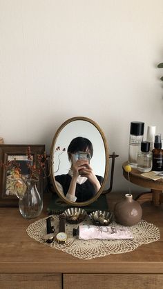 a woman taking a selfie in front of a mirror on top of a dresser