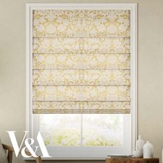 a window with roman blinds in gold and white