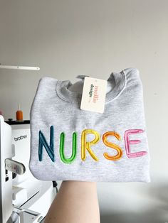 a person holding up a t - shirt with the word nurse on it