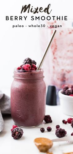 mixed berry smoothie in a mason jar with a spoon