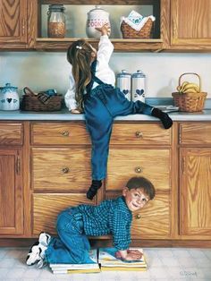 two children are standing on the kitchen counter and one boy is reaching up for something