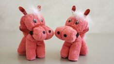 two pink stuffed animals sitting next to each other