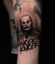 a man's arm with a joker tattoo on it and the words laugh in black ink