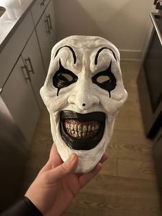 someone is holding up a mask that looks like it has been painted white