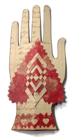 a hand made out of wood with red and white designs on the palm is shown