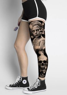 a woman's leg with tattoos on it and skulls in the bottom half of her leg