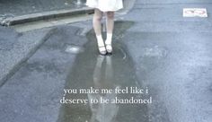 a woman walking in the rain with an umbrella over her head and words on it