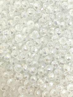 many clear beads are scattered together on a white surface