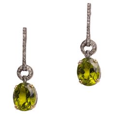 A lovely pair of drop earrings with large, faceted oval peridot gemstones with round, brilliant cut diamonds in a pave` 8..setting in sterling silver. 18K gold post for pierced ears. Carat weight of peridot stones total 8.55 carats. Diamonds total .25 carats. The fine jewelry collection is sourced, designed or created by Deborah Lockhart Phillips. Through her international travels, she has cultivated prime resources for fine precious and semi-precious gemstones of unusual cuts in a variety of se Peridot Stone, Peridot Gemstone, Diamond Drops, Fine Jewelry Collection, Diamond Drop Earrings, Precious Gemstones, 22k Gold, Pierced Ears, Round Brilliant Cut