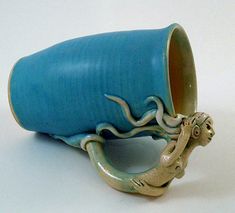 a ceramic cup with an octopus on it's side and its mouth sticking out