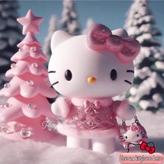 a hello kitty figurine standing next to a pink christmas tree in the snow