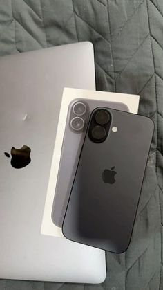 two iphones sitting next to each other on a bed