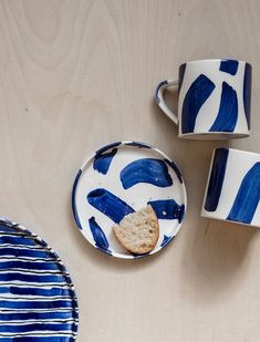 two blue and white plates, one with a piece of bread on it next to another plate