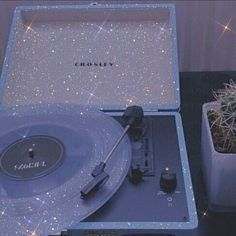 a record player sitting on top of a table next to a cactus