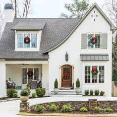 a white house with wreaths on the front door