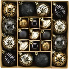 an open box filled with black and gold christmas ornament ornaments in leopard print boxes