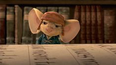 a cartoon mouse wearing a hat and sitting at a table in front of some books